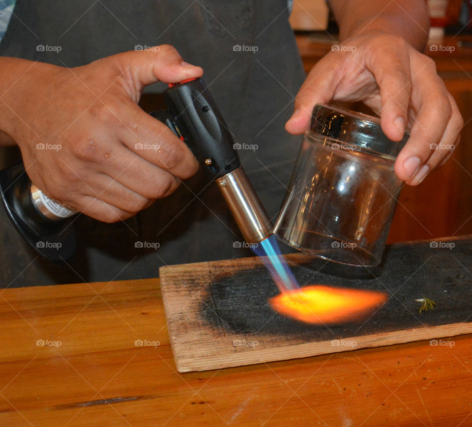 Close-up of a person heating wooden plank