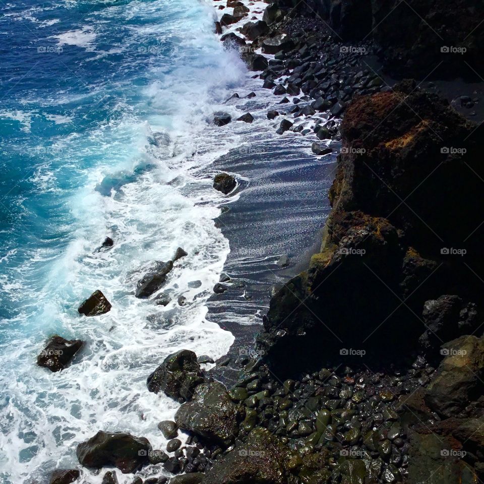 Black sand, blue ocean