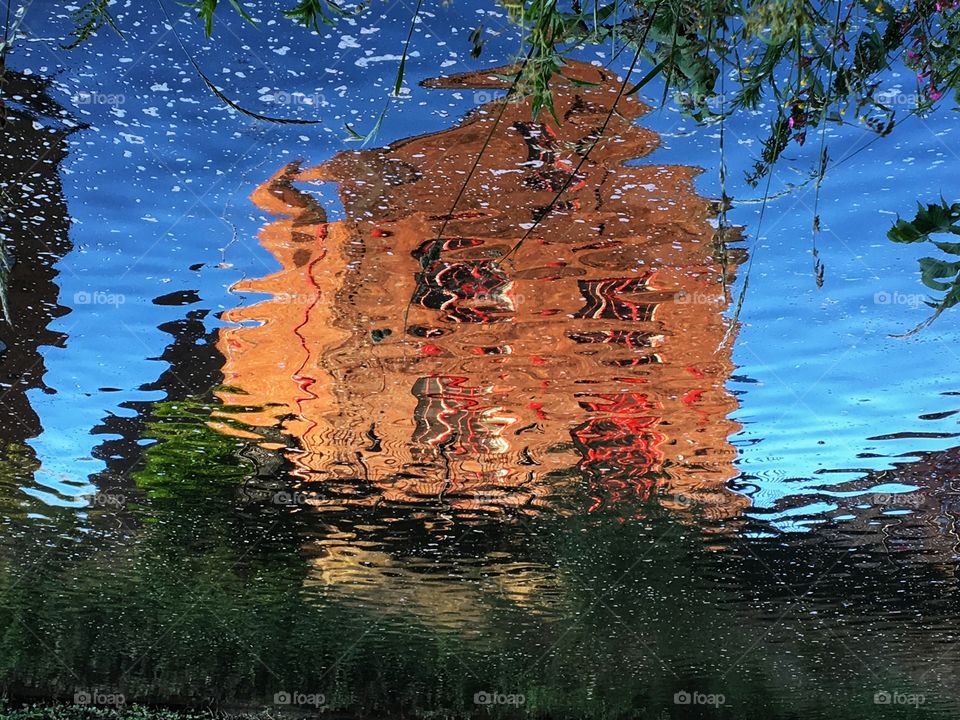 River reflection of a converted wharf house ... interesting red ripples created from the red iron balcony and red door 