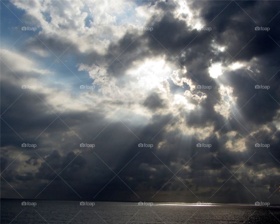 STORM CLOUDS ON OCEAN, black clouds & blue sky with suns rays!