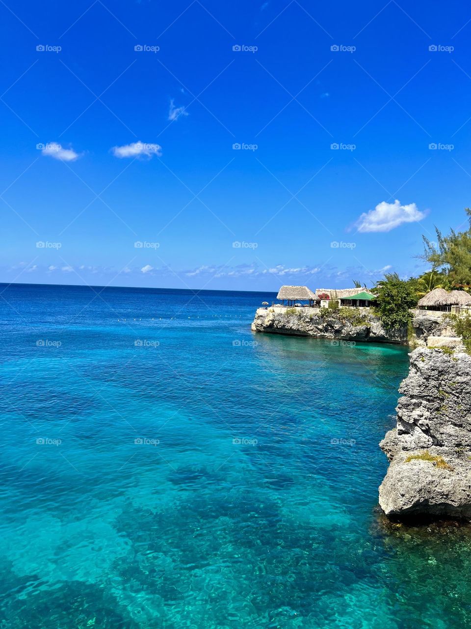 Perched atop rugged cliffs, Rick's Café in Jamaica offers a panoramic Caribbean view. The azure sea stretches into the horizon, while a vibrant sunset paints the sky. It's a mesmerizing sight that encapsulates the island's raw, natural beauty.