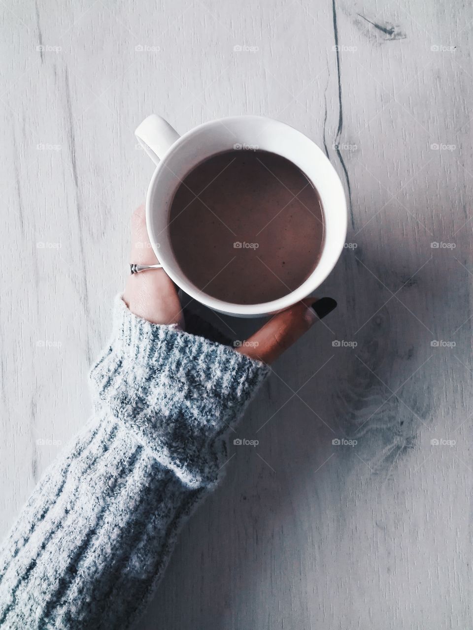 Close-up of women's hand with cup of coffee