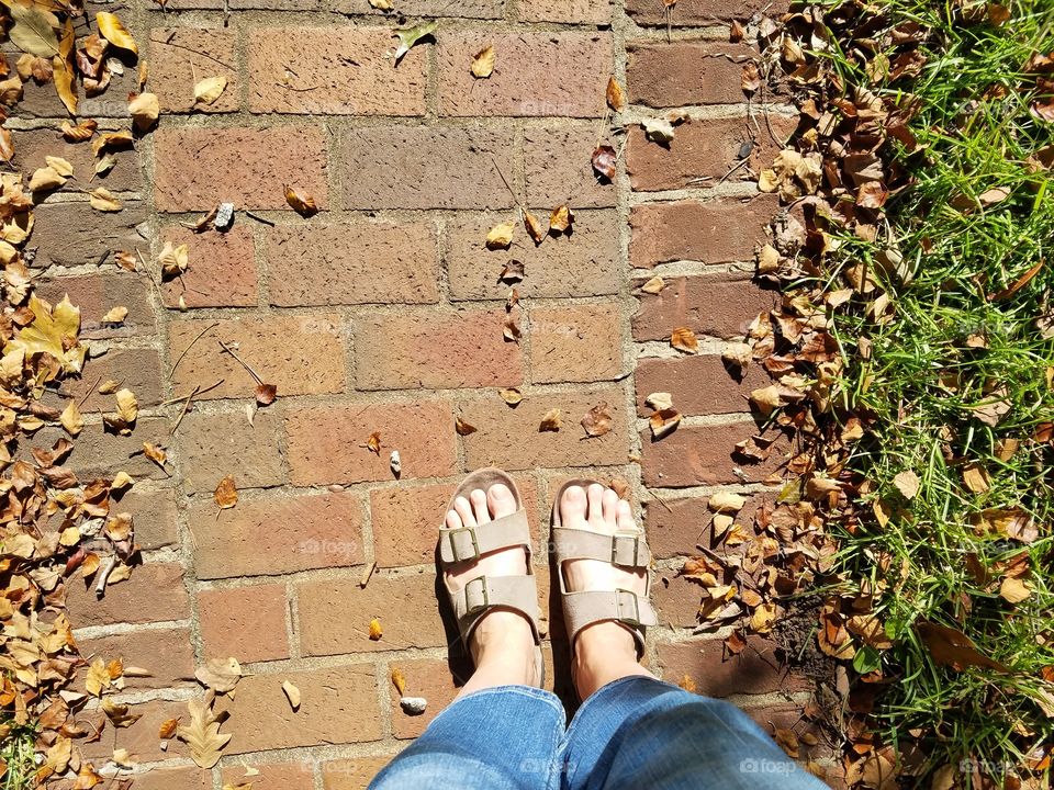 feet on a brick sidewalk