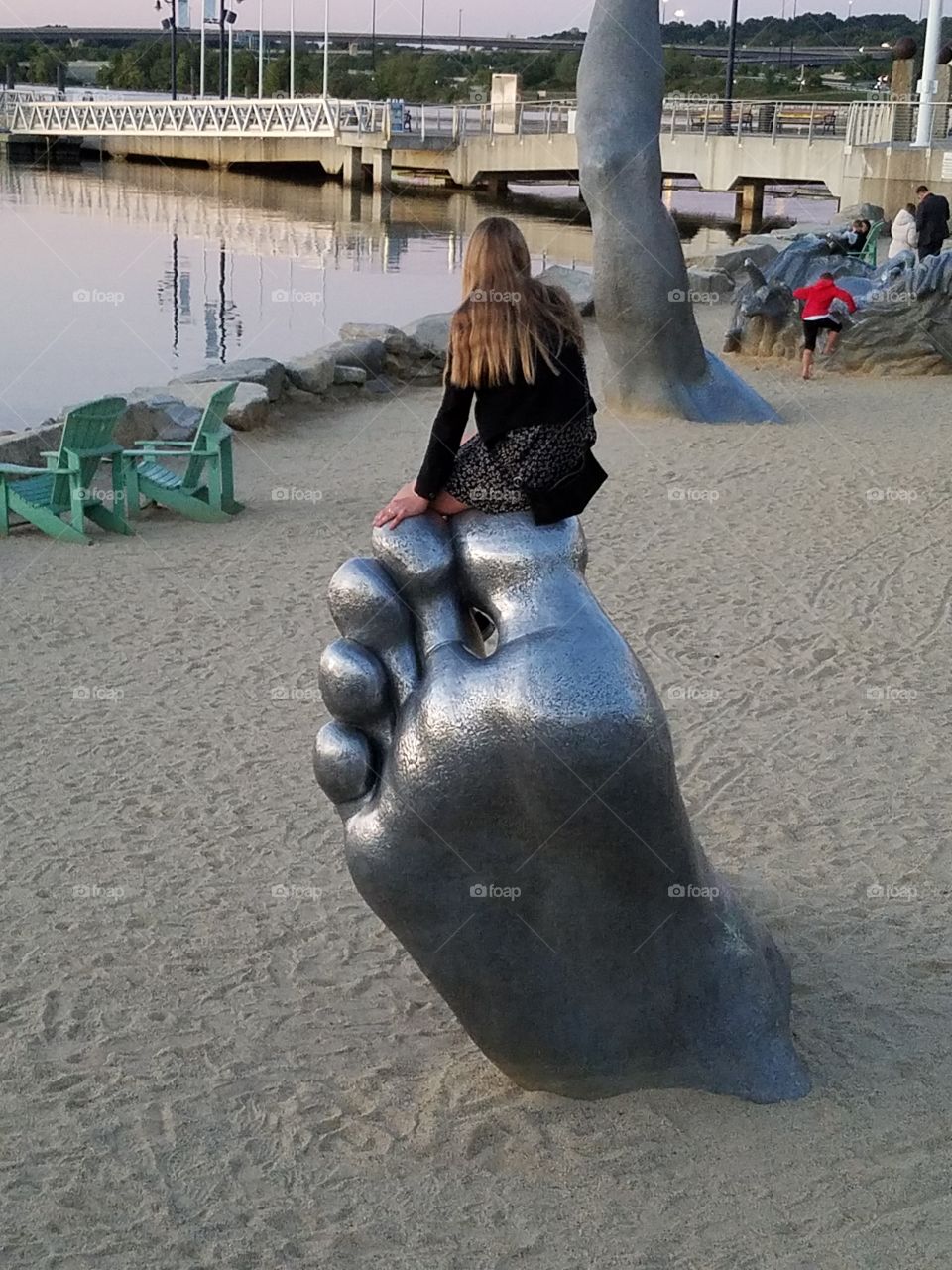 Girl sitting on big toe statue