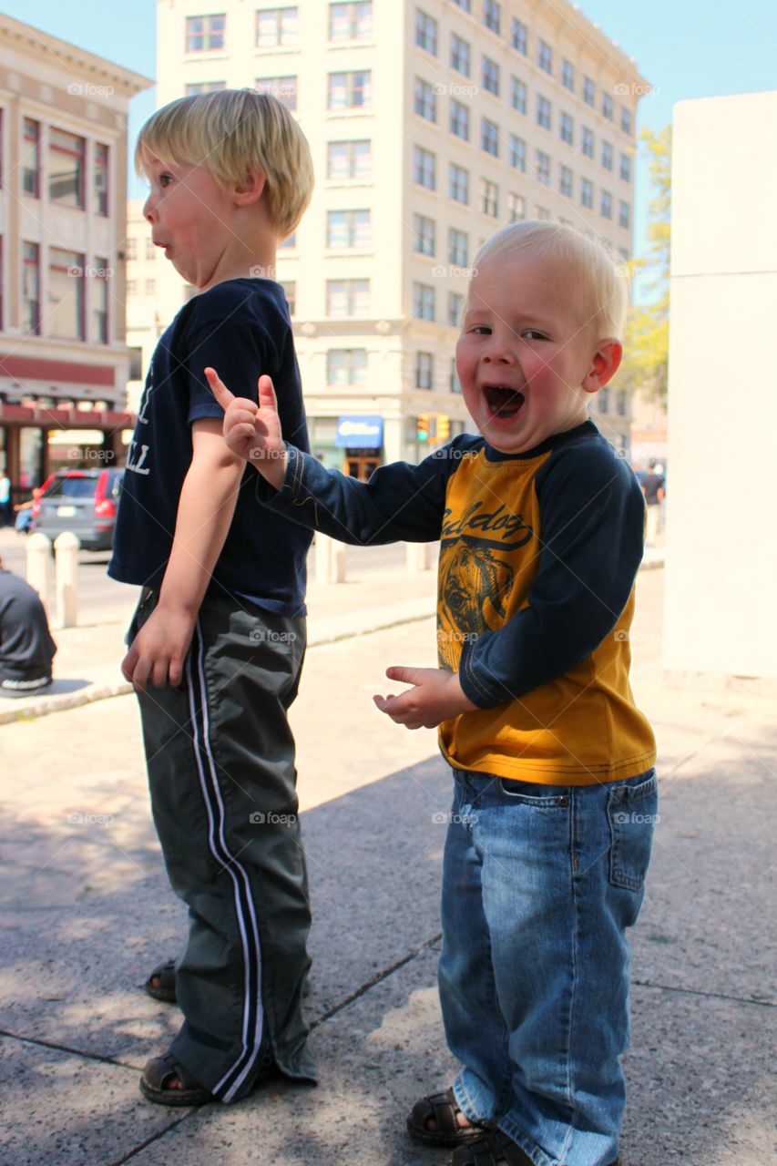 Brothers making faces standing on street