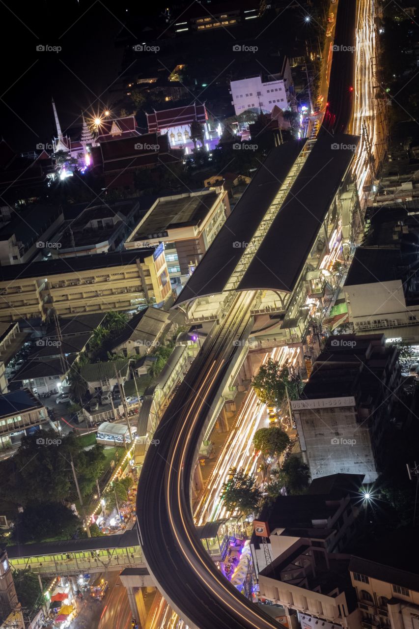 Bird eyes view from City tower of Samut Prakan province to show Light of Electric railway and car on road , Thailand