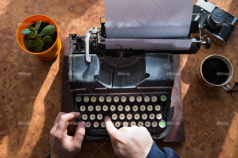 A young writer is writing a new book on an old typewriter.