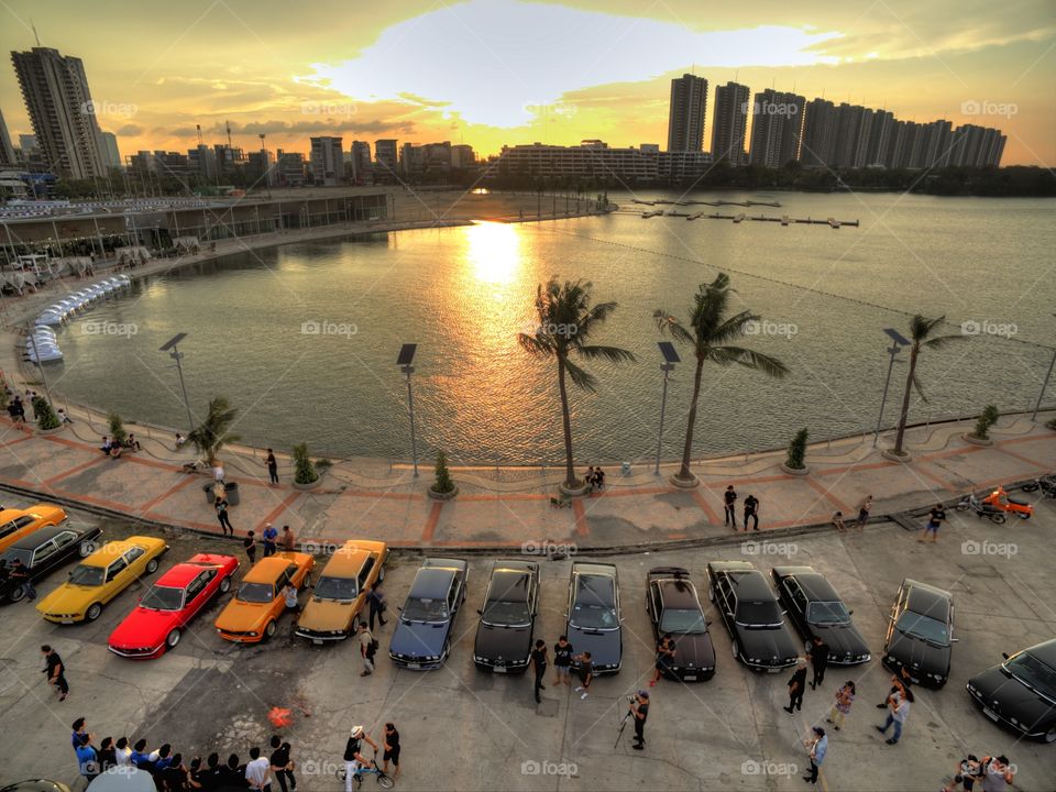 drone aerial view from above of bmw cars parked next to a lake