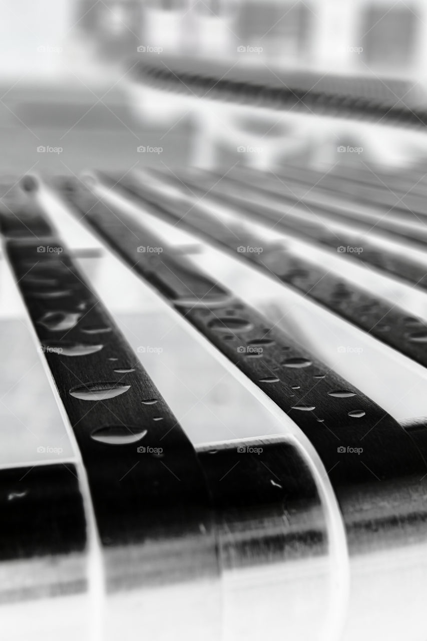 Metal bench after the rain negative image