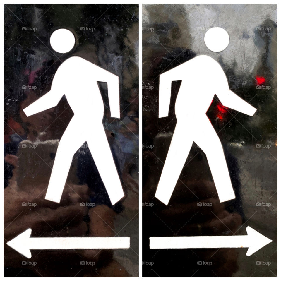 Back to back walk signs with blurry reflections from the street 