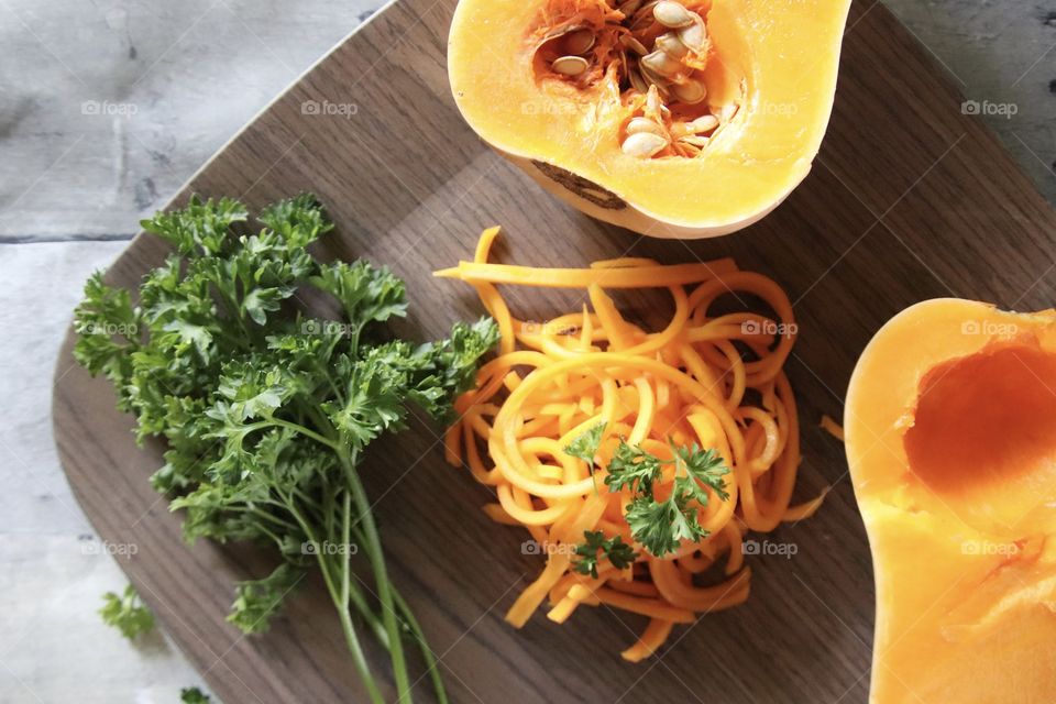 Fresh green parsley and orange butternut squash displayed on plate