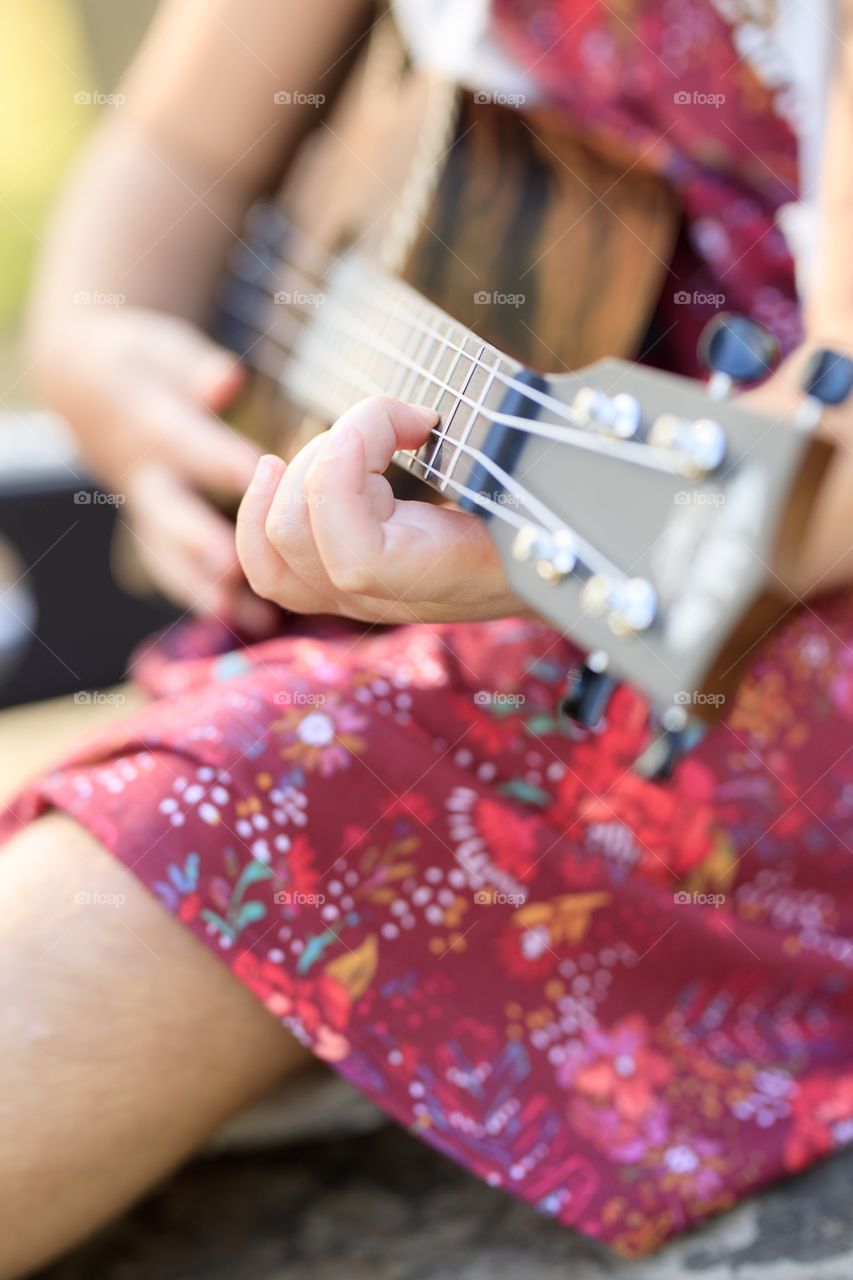 Close up of girls hands playing acoustic guitar. 
