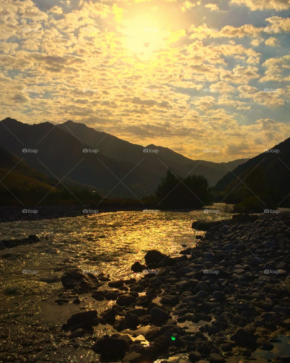 Gold sunset reflection in a mountain river 