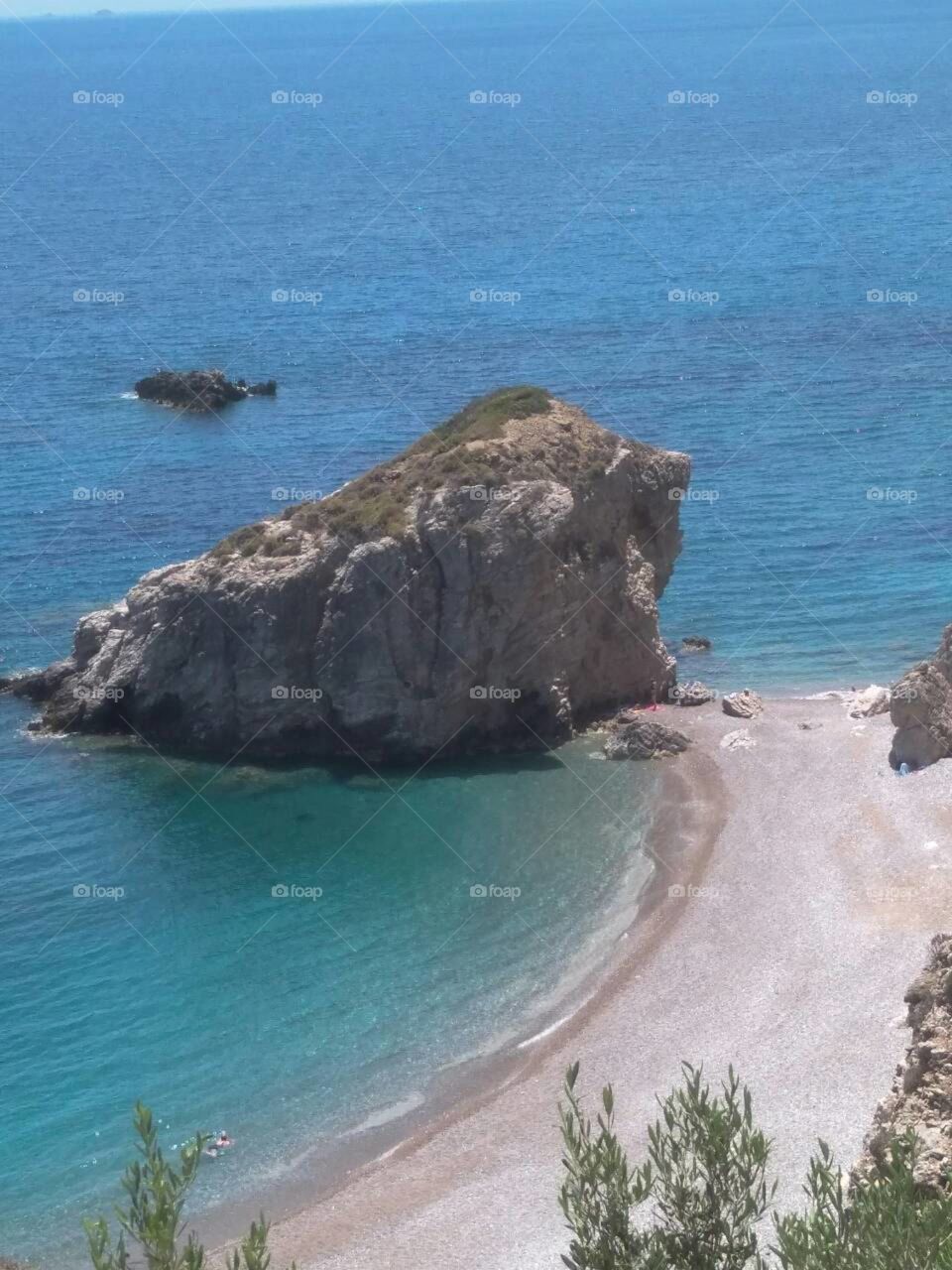 Beautiful beach with a big rock. Shot from above. Secret beaches of Greece.