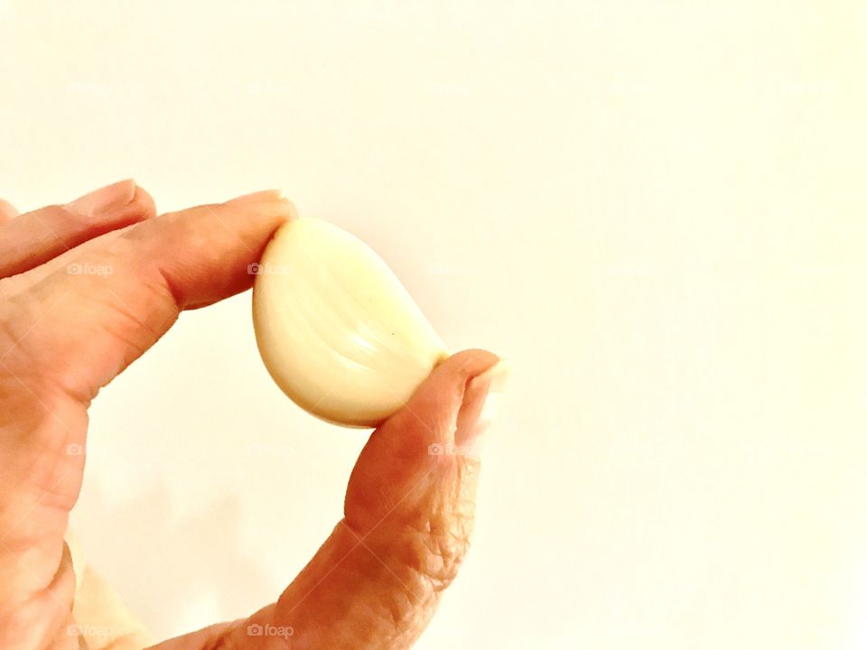 Fingers holding clove of garlic