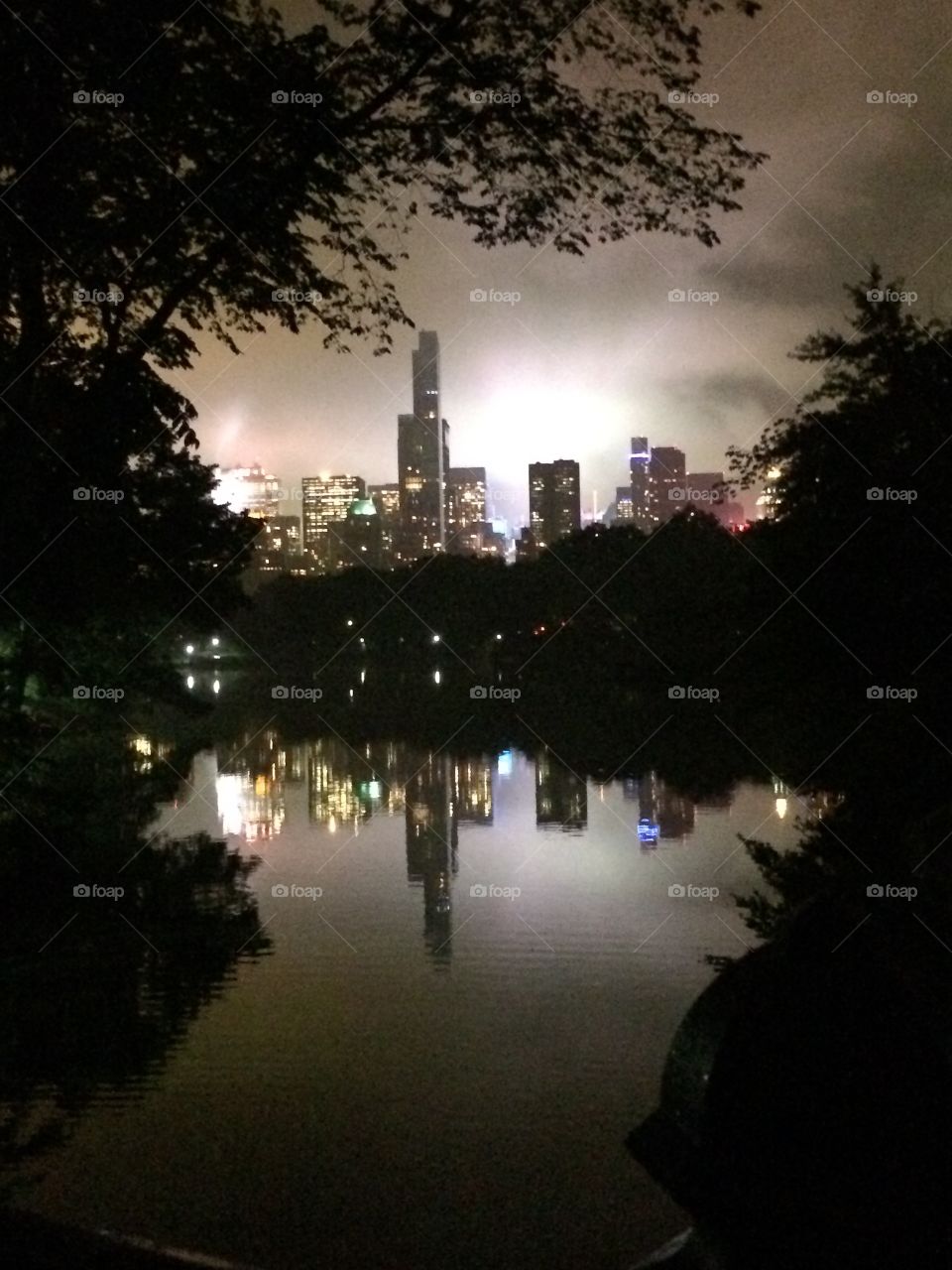 Reflection on a lake of Nyc through Central Park at night 