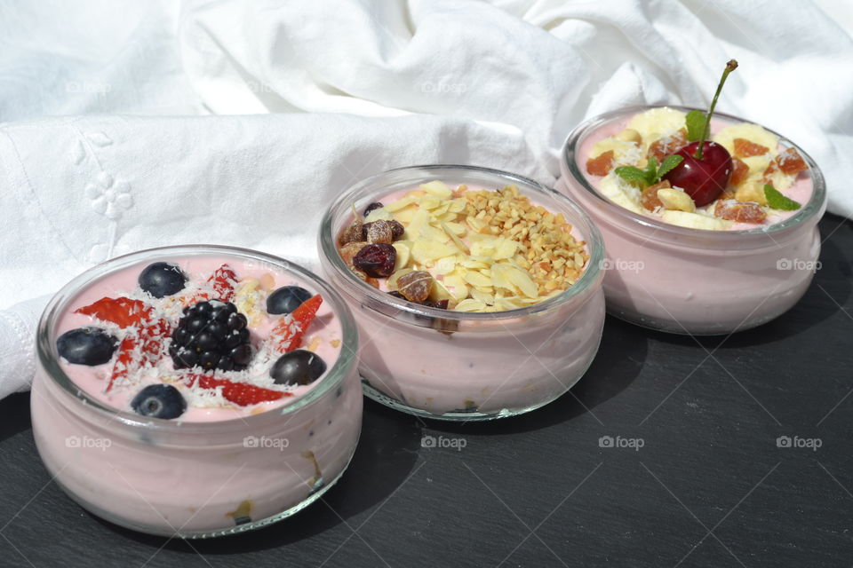 Delicious yogurts with berries in bowl