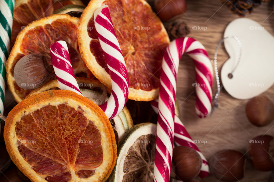 Christmas candy canes with dehydrated orange slices. Top view.