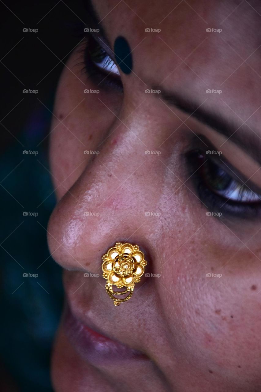 Close up of an Indian lady wearing gold nosepin