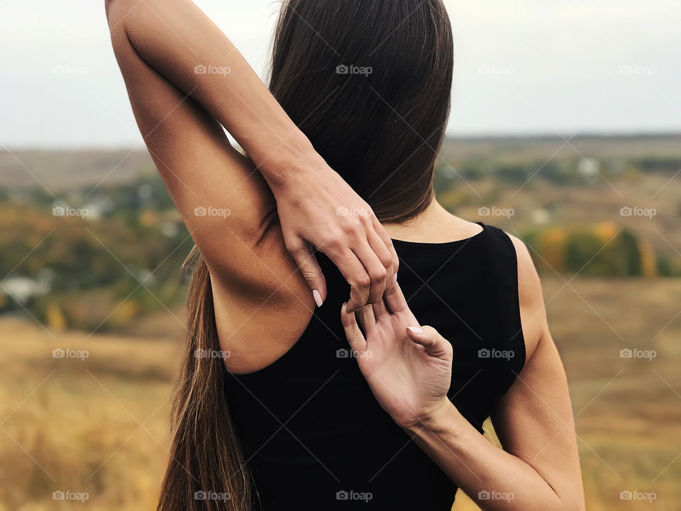 Young woman with long hair exercising outdoors 