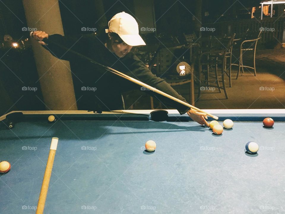 A woman practicing playing pool
