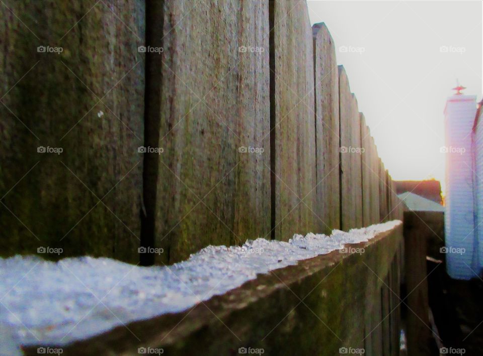 snow on fence rail