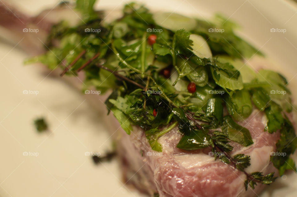 Classic French Cuisine mainstay preparation Fines herbs with red peppercorn being prepared on fresh meat from the butcher parsley, chervil, tarragon, chives, with thyme 