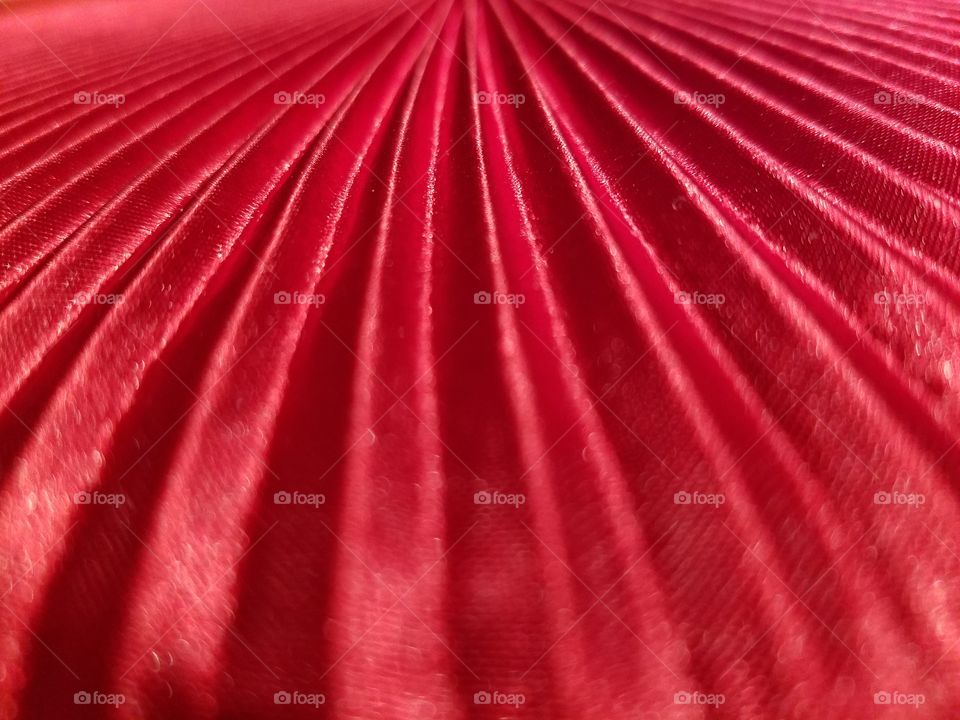 red satin fabric pleated. vibrant red, color, textile, design, perspective and still-life photo.