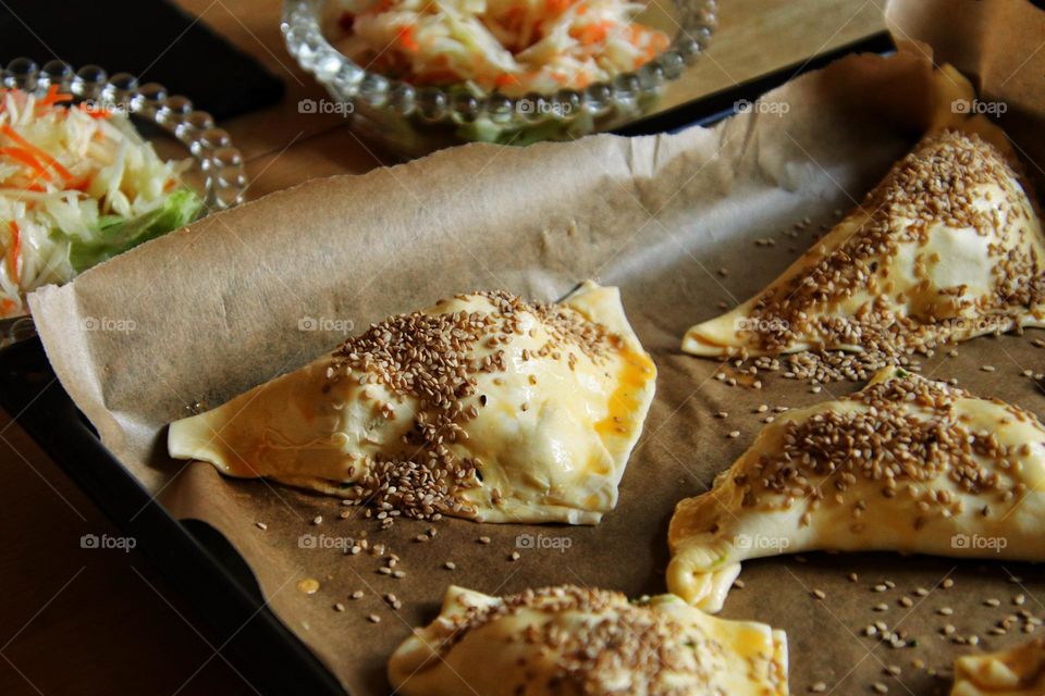 Close-up of homemade puff pastry with sesame seeds on baking sheet