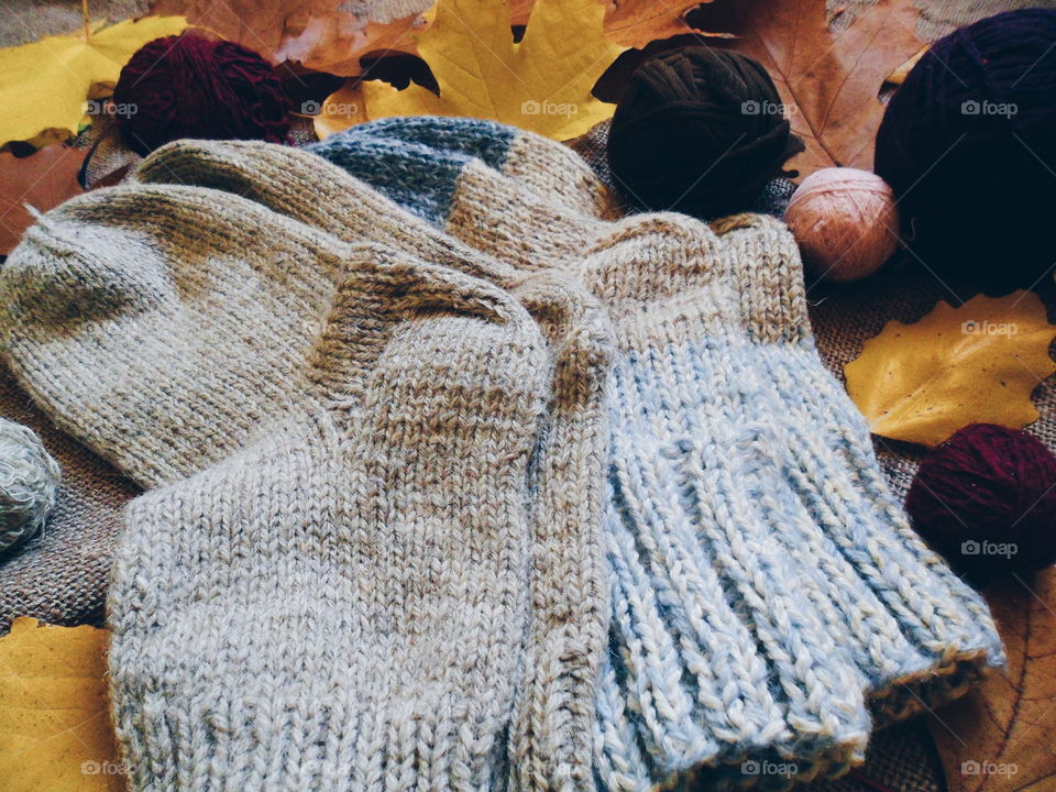 knitted warm socks and autumn leaves