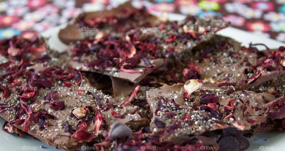 More Chocolate - Hibiscus Chia Chocolate Bark on a white plate, bright floral tablecloth