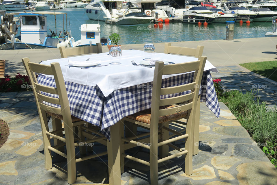 Greek taverna table by a hotel marina in Greece. A greek restaurant table by the marina at a resort in Halkidiki, Greece.