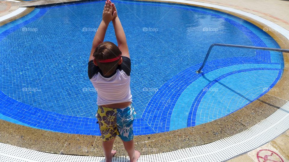 Young kid about to take a deep dive into a shallow pool