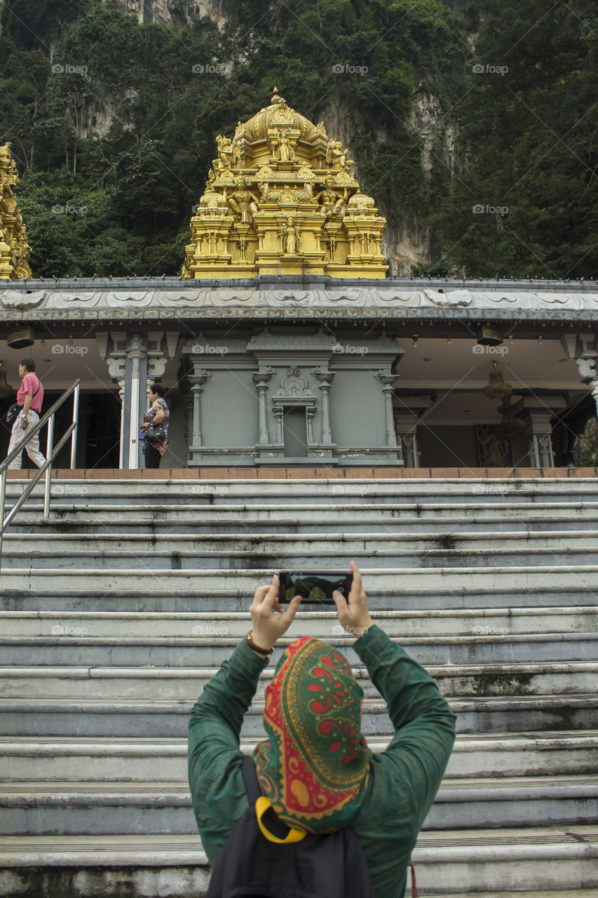 A Muslim Tourist with Hijab photographing in Batu Caves, Kuala Lumpur, Malaysia