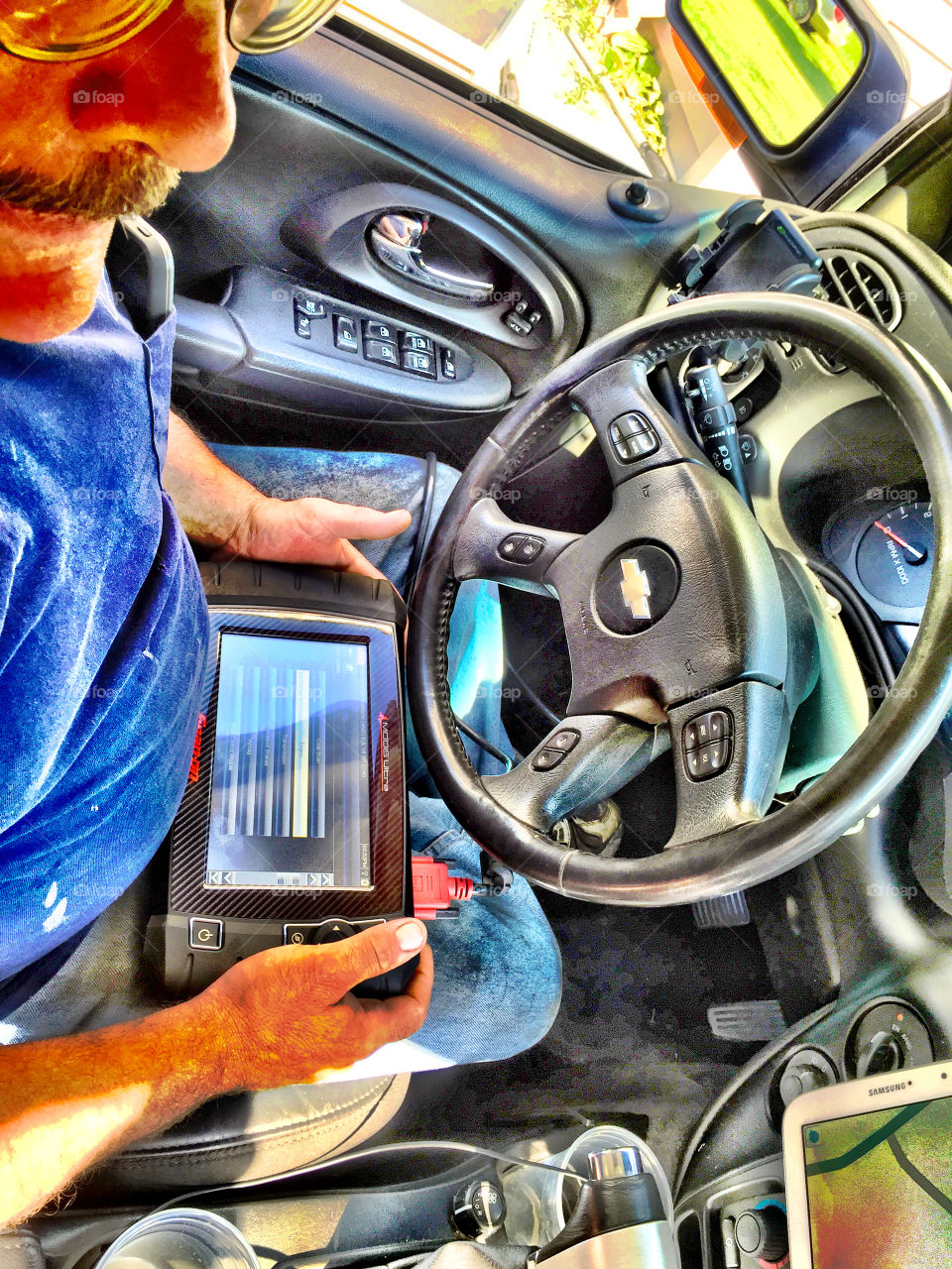Mechanic. My mechanic working on my Chevy Trailblazer with his tablet. 