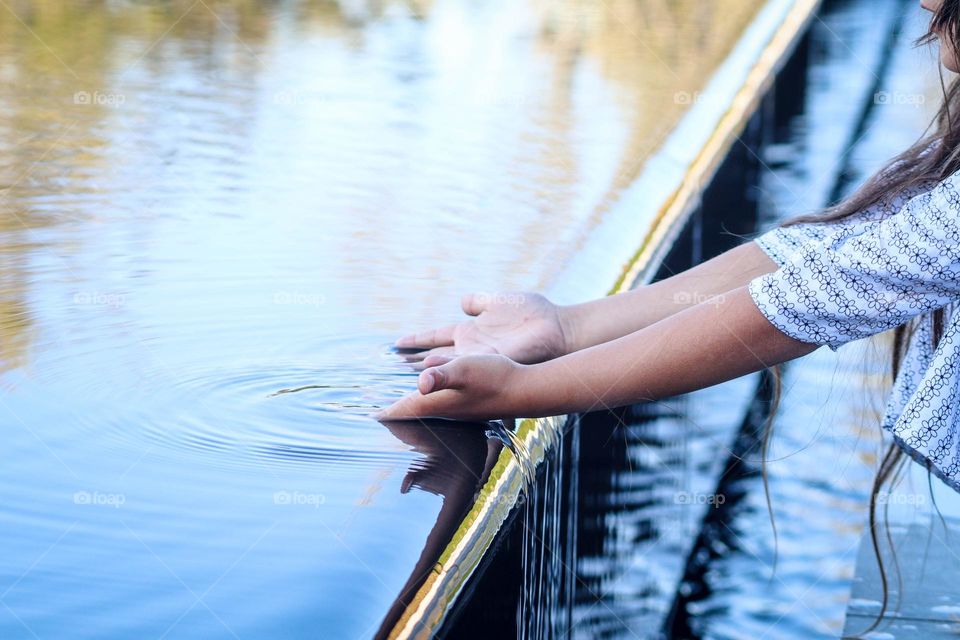 Child is playing with water in a fontain