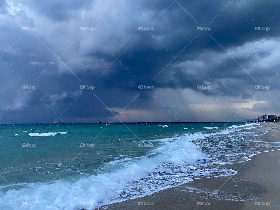 Storm clouds moving in over a beach at sunset