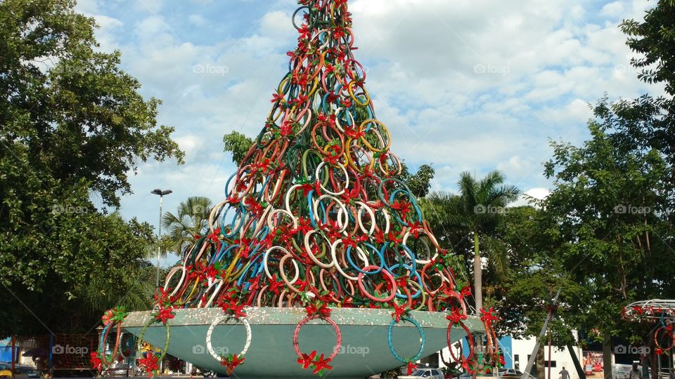 Reciclagem. Escultura de arvore de natal, sobre fonte de praça. Com muitos pneus velhos de bicicletas, pintados com varias cores.