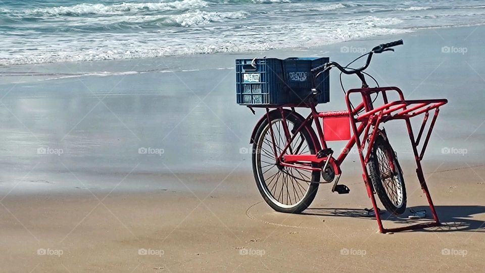 The solitary bicycle waits on a beautiful deserted beach for its owner who left it to take a swim in the sea, in this wonderful landscape.