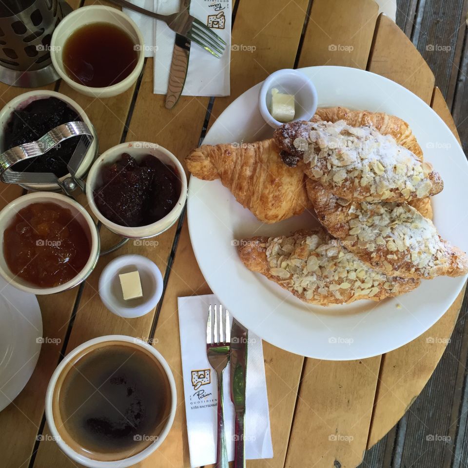 Classic breakfast of assorted croissants, butter, jam and coffee.