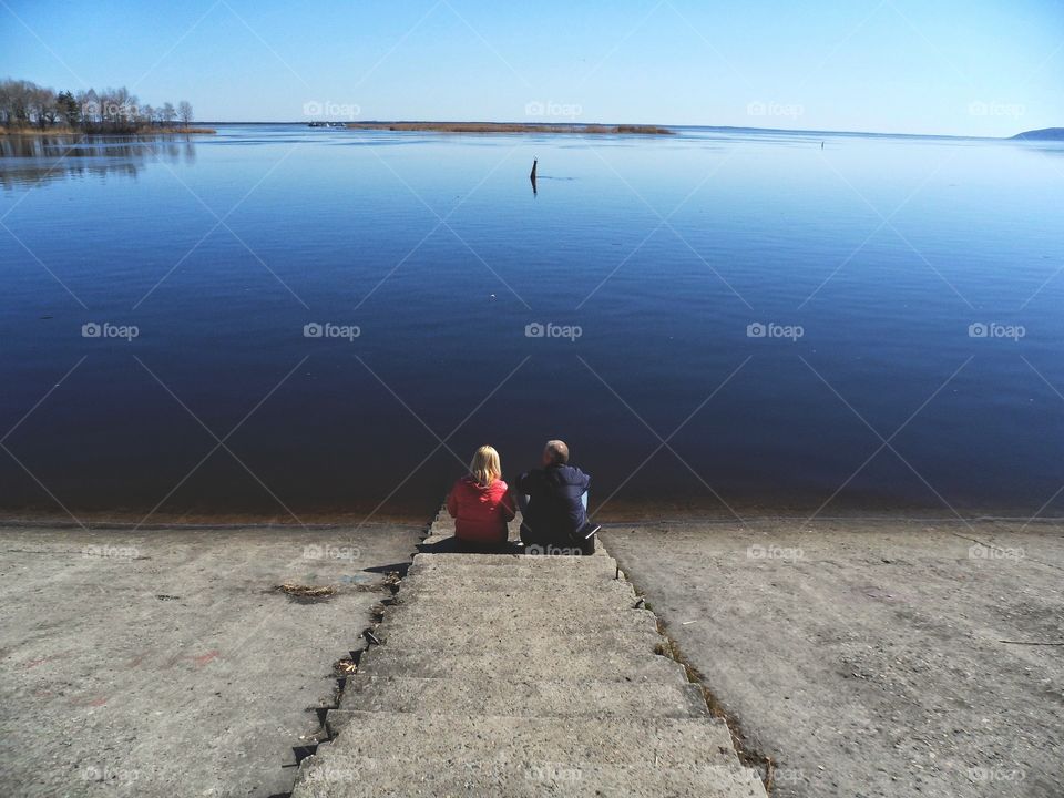 a man and a woman are sitting on the banks of the Dnieper River