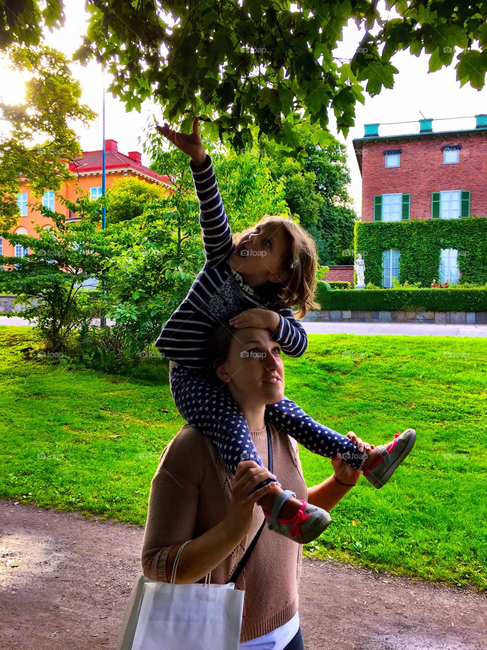 Woman carrying her daughter on shoulder