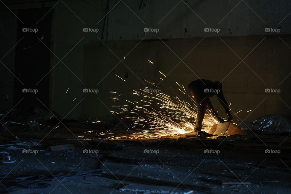 Worker cutting steel in factory