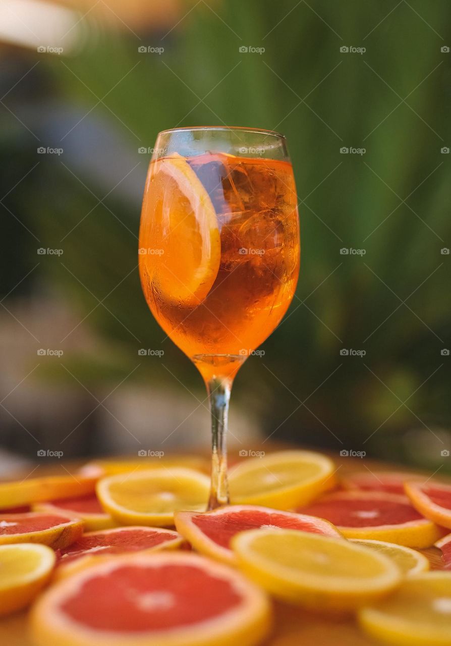 a delicious, summer, alcoholic cocktail, on the table in a restaurant, with lots of ice and orange inside, fresh and aromatic