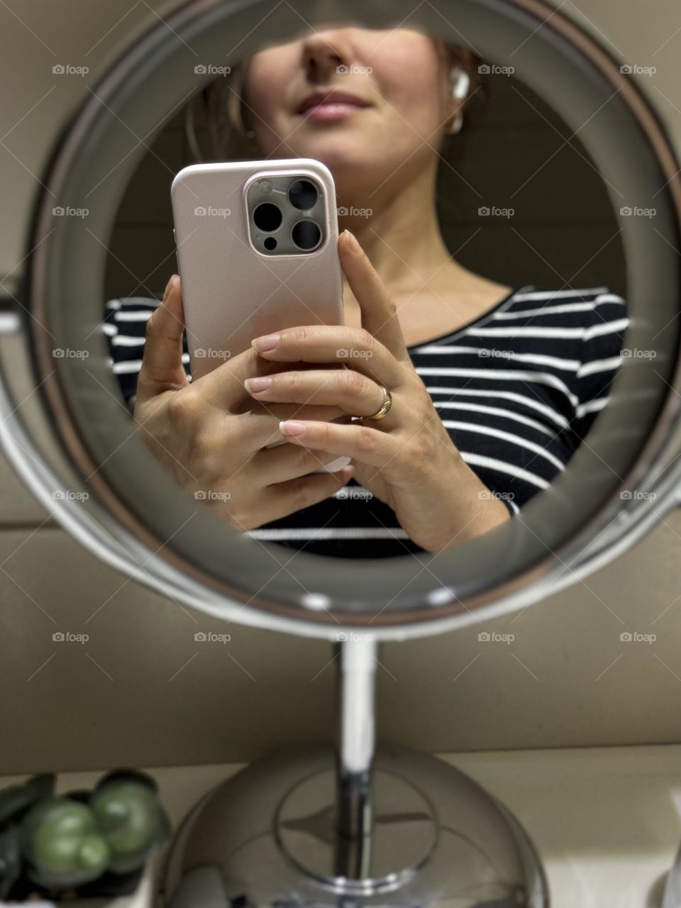 Woman’s portrait with product, girl holding an iPhone in her hands 