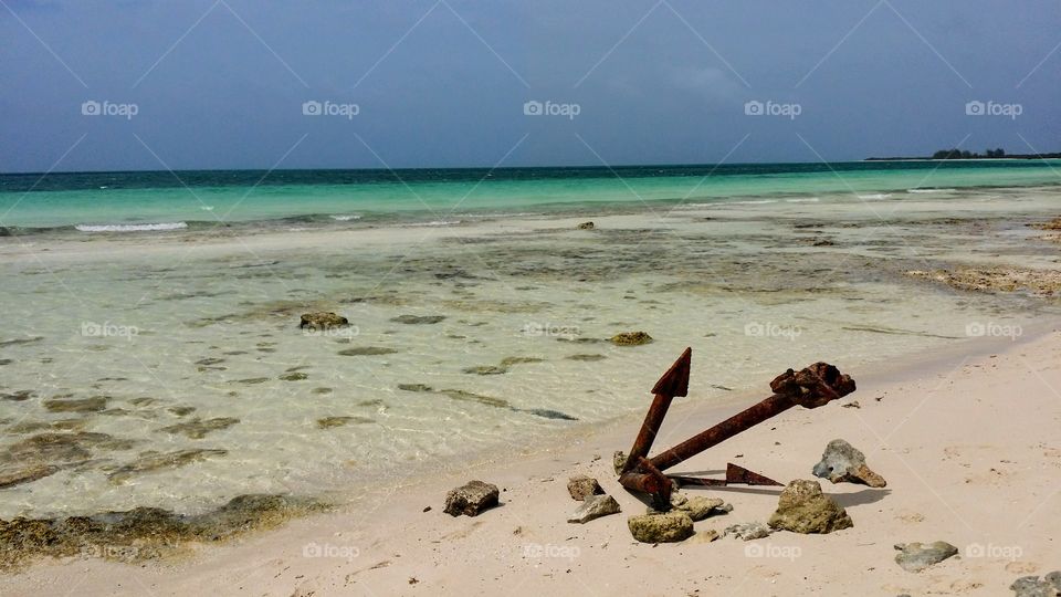 Anchor on a white sand beach of Cuba, turquoise sea and blue sky