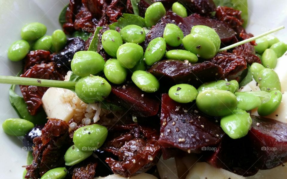 edamame beets quinoa hearts of Palm sun dried tomatoes spinach salt pepper salad close up