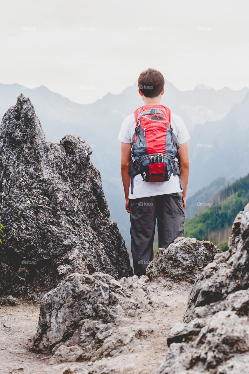 Trip in the mountains. Boy standing on the rocks in The Tatra Mountains