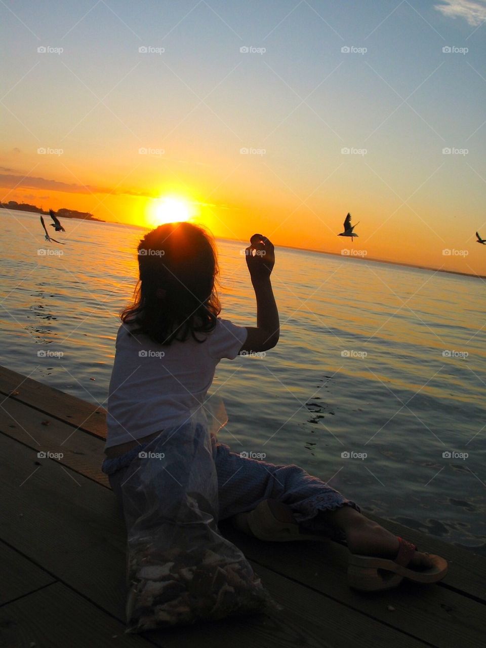 Sunset child feeding birds