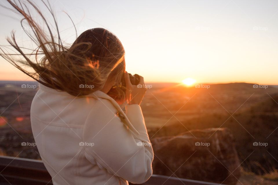 Woman taking a picture of the sunrise 